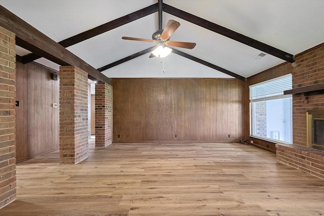 unfurnished living room with vaulted ceiling with beams, wood walls, ceiling fan, and light hardwood / wood-style flooring