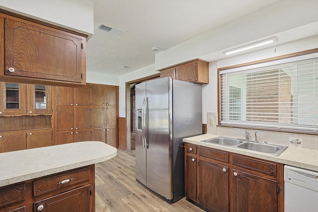 kitchen with dishwasher, stainless steel fridge with ice dispenser, light hardwood / wood-style flooring, and sink