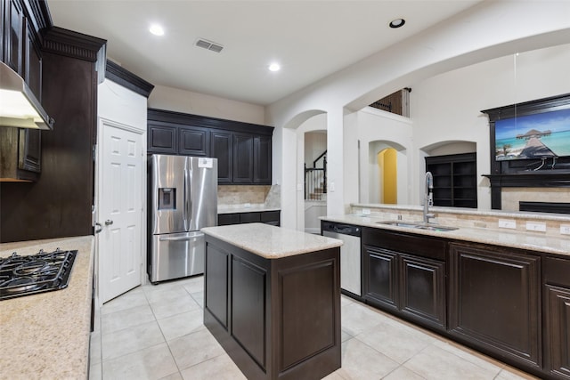 kitchen featuring light tile patterned flooring, sink, tasteful backsplash, a kitchen island, and stainless steel appliances