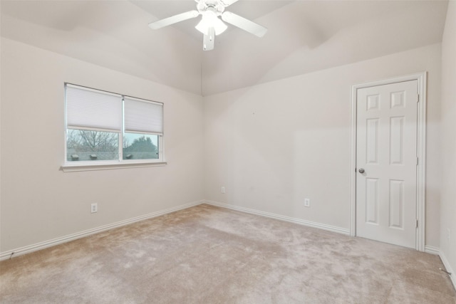 empty room featuring lofted ceiling, light carpet, and ceiling fan