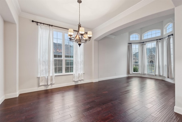 empty room with ornamental molding, dark hardwood / wood-style floors, and a chandelier