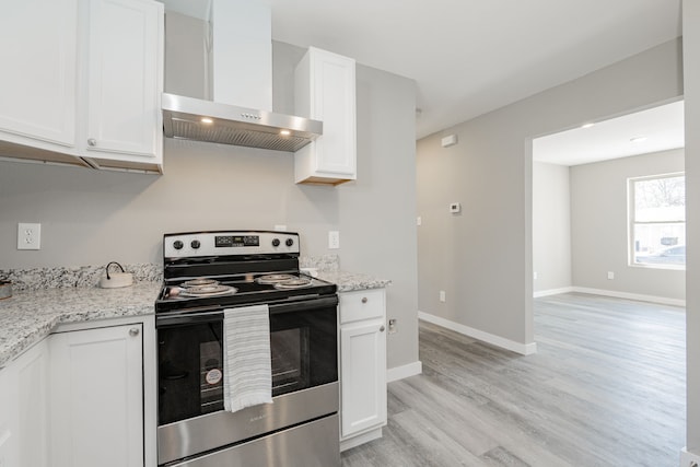 kitchen with white cabinets, stainless steel electric range oven, light wood-style floors, and wall chimney range hood