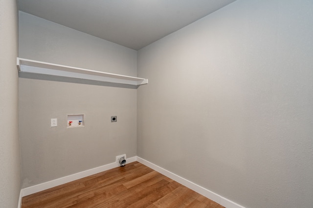 clothes washing area featuring baseboards, light wood-type flooring, laundry area, hookup for a washing machine, and hookup for an electric dryer