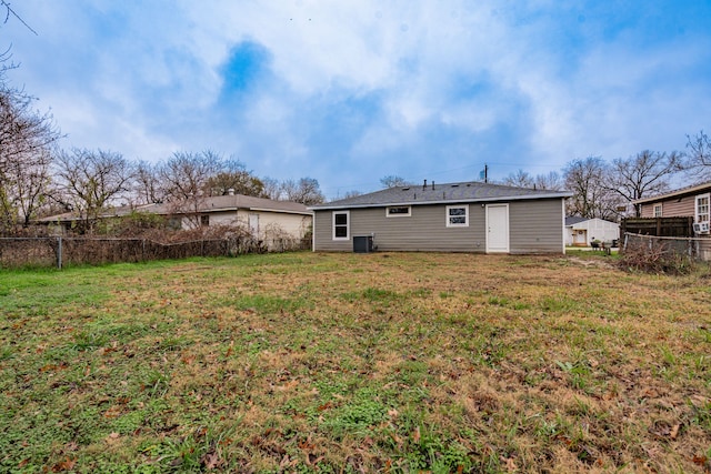 rear view of property with a lawn and central air condition unit