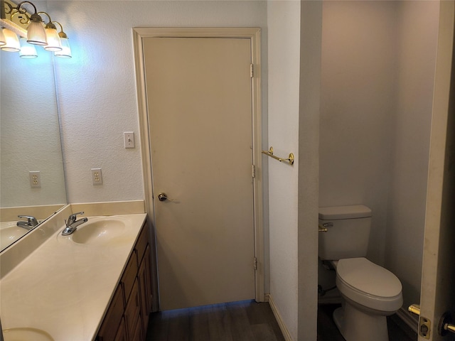 bathroom with vanity, hardwood / wood-style flooring, and toilet