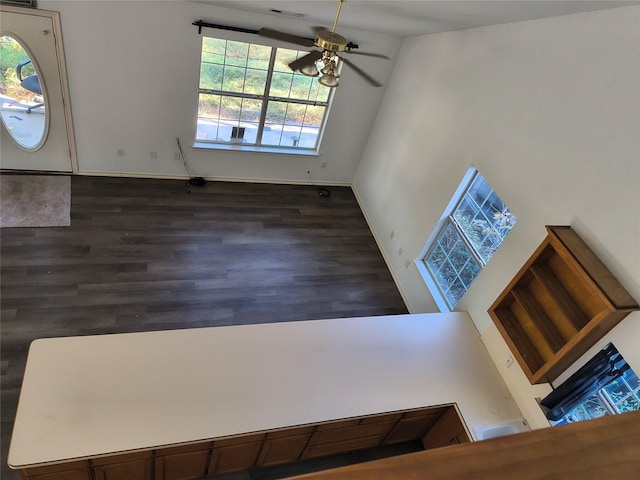 interior space with ceiling fan, dark hardwood / wood-style flooring, and a high ceiling