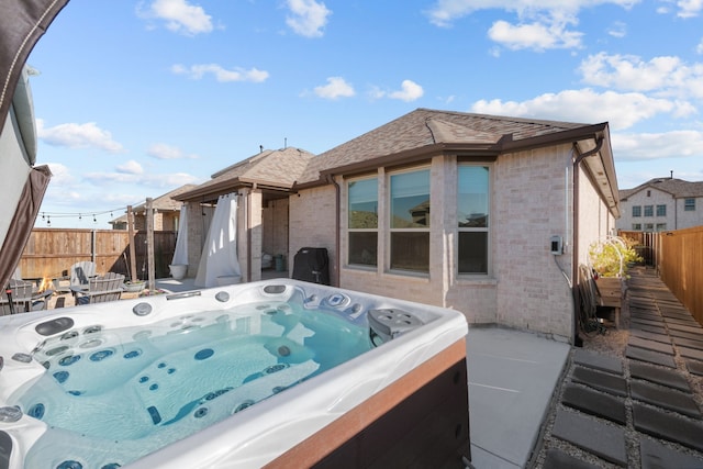 back of house with a hot tub