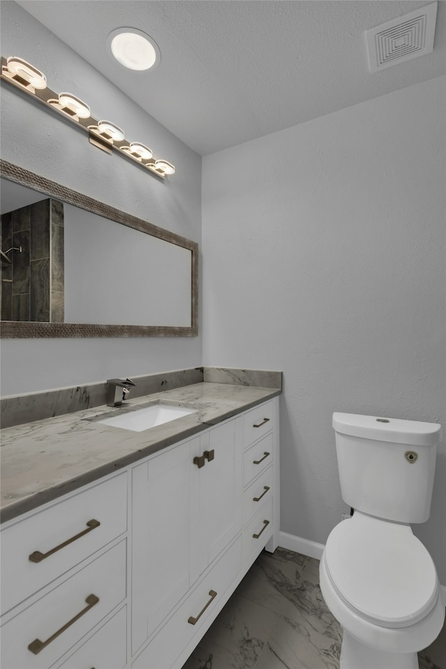 bathroom featuring toilet, vanity, and a textured ceiling