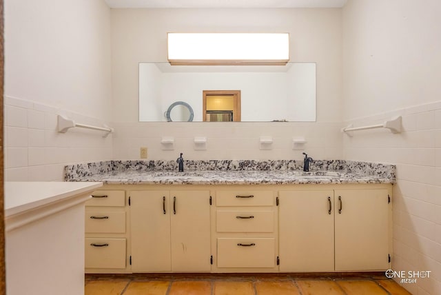 bathroom featuring vanity and tile walls