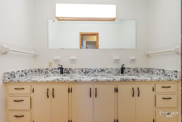 bathroom with vanity and tile walls