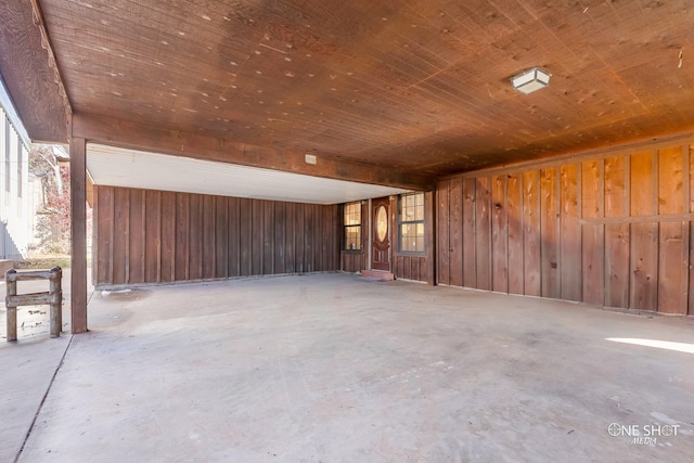 empty room with concrete floors and wood walls