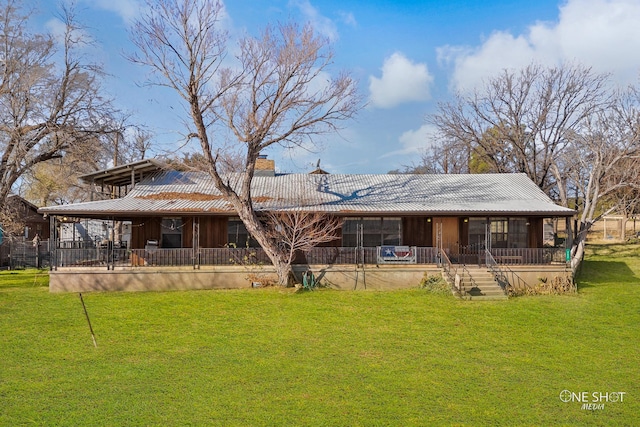 rear view of property featuring a yard