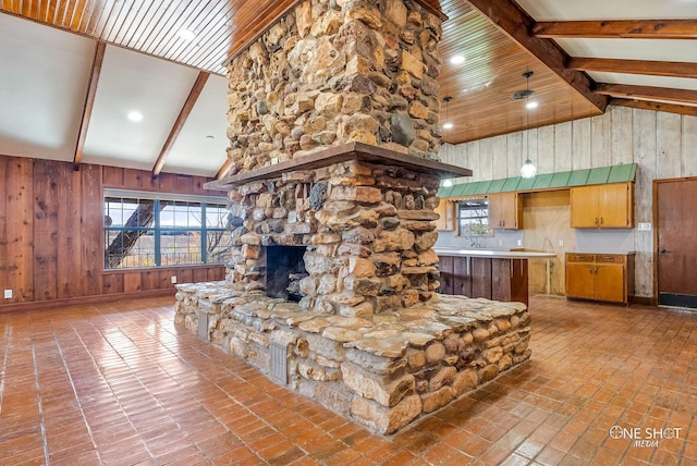 living room with high vaulted ceiling, a fireplace, beamed ceiling, wooden walls, and ceiling fan