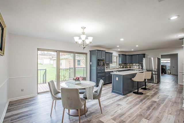 dining area featuring light wood-type flooring and an inviting chandelier