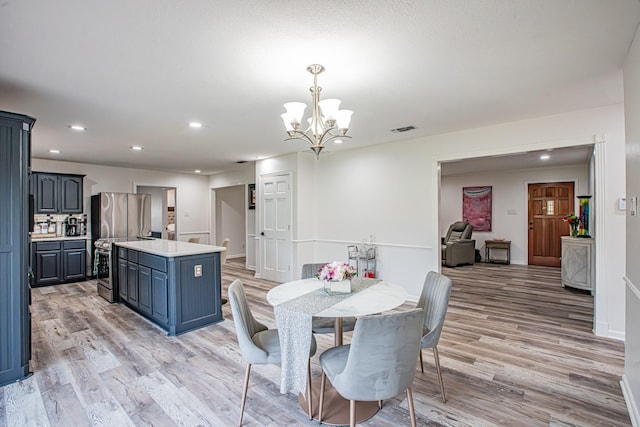 dining area with an inviting chandelier and light hardwood / wood-style floors