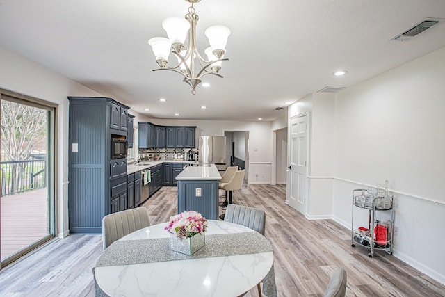 dining room featuring a chandelier, sink, and light hardwood / wood-style floors