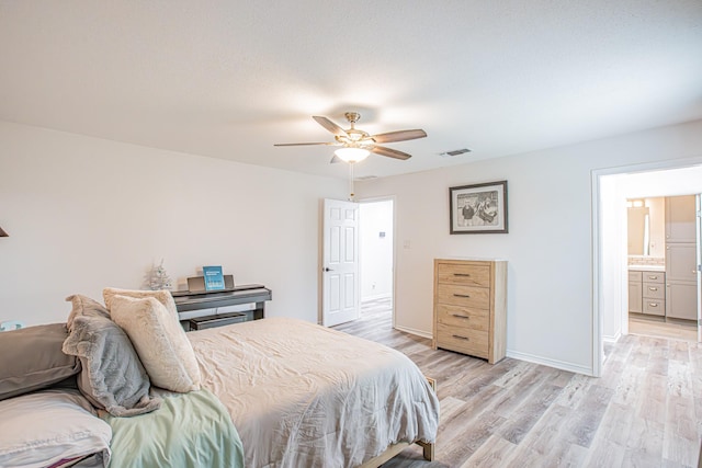 bedroom featuring ceiling fan, light wood-type flooring, and ensuite bath