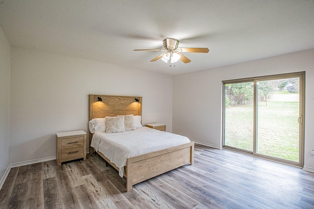 bedroom featuring hardwood / wood-style flooring, access to exterior, and ceiling fan