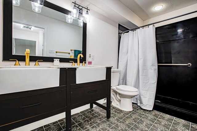 bathroom featuring vanity, a textured ceiling, toilet, and walk in shower