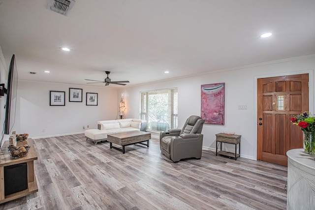 living room with ceiling fan, light wood-type flooring, and ornamental molding