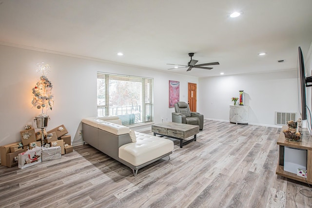 living room with crown molding, ceiling fan, and light wood-type flooring