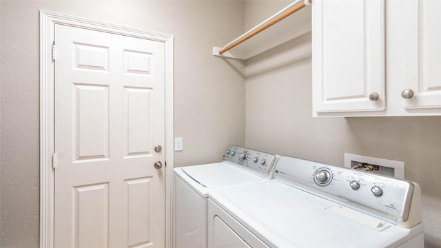 laundry room with washer and dryer and cabinets