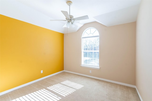 carpeted empty room with vaulted ceiling and ceiling fan