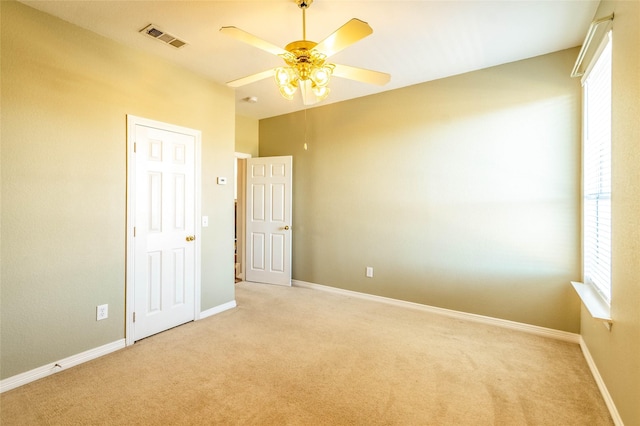 interior space with light carpet and ceiling fan