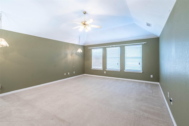 carpeted spare room with ceiling fan and vaulted ceiling