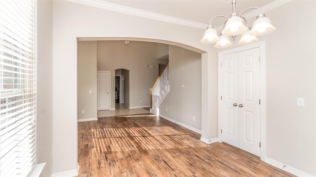 interior space with crown molding, hardwood / wood-style floors, and an inviting chandelier