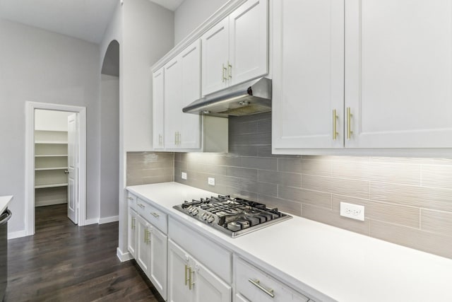 kitchen featuring decorative backsplash, white cabinetry, dark wood-type flooring, and stainless steel gas cooktop