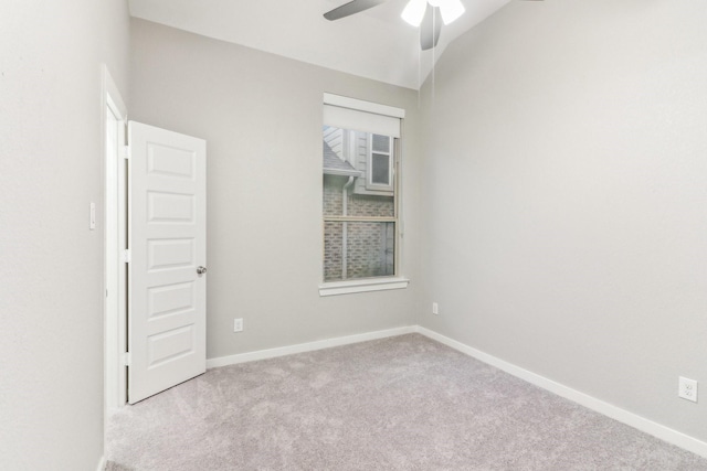 carpeted spare room featuring ceiling fan and lofted ceiling