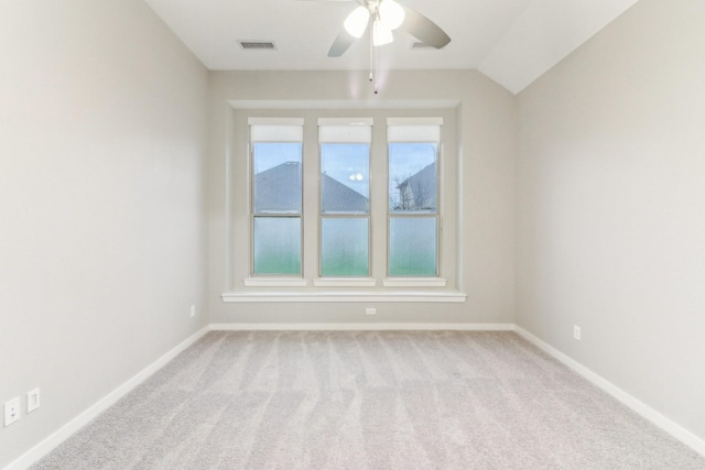 empty room featuring light colored carpet, vaulted ceiling, and ceiling fan