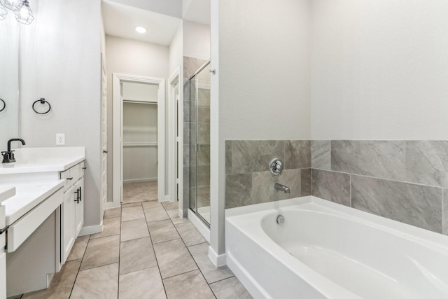 bathroom featuring shower with separate bathtub, vanity, and tile patterned floors