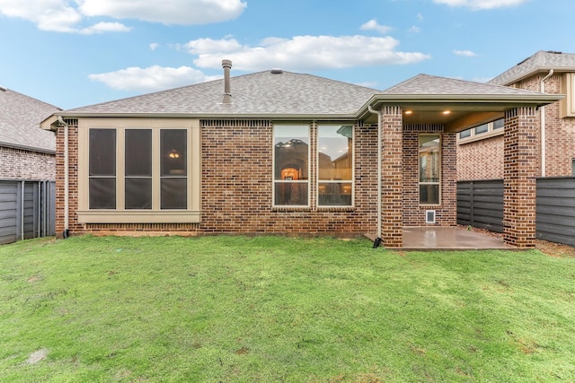 rear view of house with a yard and a patio