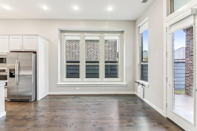 kitchen featuring white cabinets, appliances with stainless steel finishes, dark hardwood / wood-style floors, and a wealth of natural light