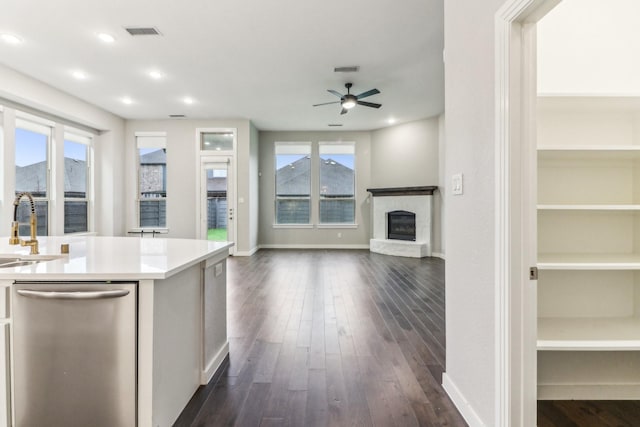 kitchen featuring dishwasher, a mountain view, dark wood-type flooring, ceiling fan, and a fireplace