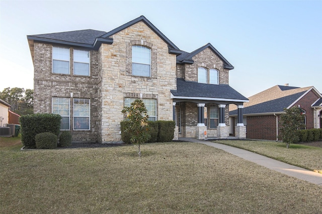 view of front facade featuring central AC unit, covered porch, and a front yard