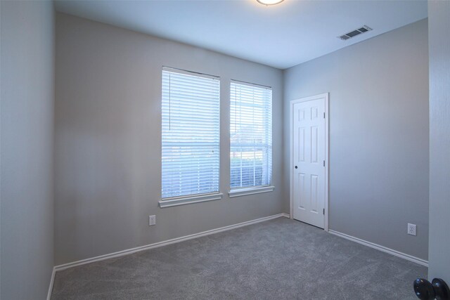 unfurnished room featuring dark colored carpet