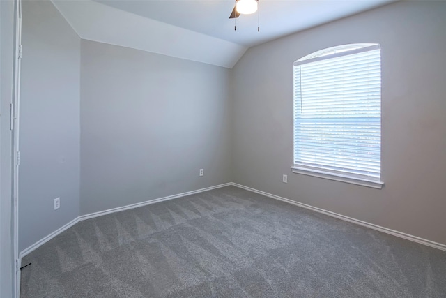 carpeted spare room featuring ceiling fan, plenty of natural light, and vaulted ceiling