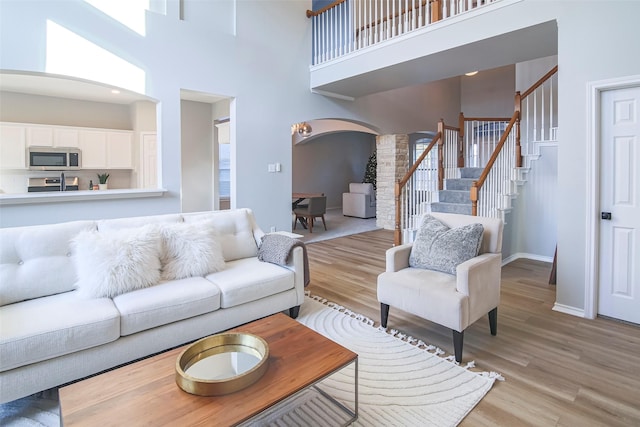 living room with light hardwood / wood-style floors and a high ceiling