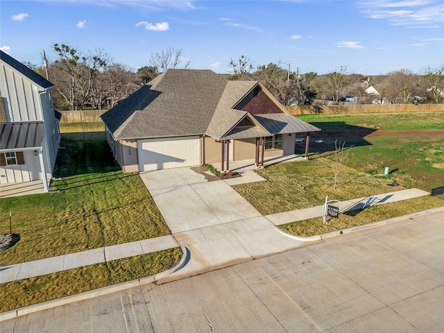 view of front of house with a front yard, a porch, and a garage