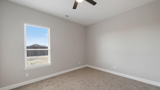 carpeted spare room featuring ceiling fan