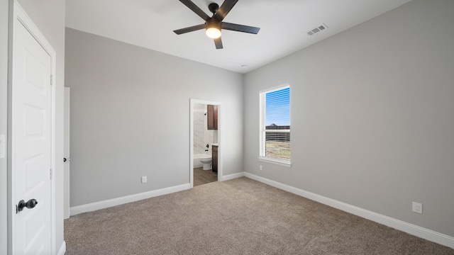 unfurnished bedroom with ceiling fan, ensuite bathroom, and carpet floors