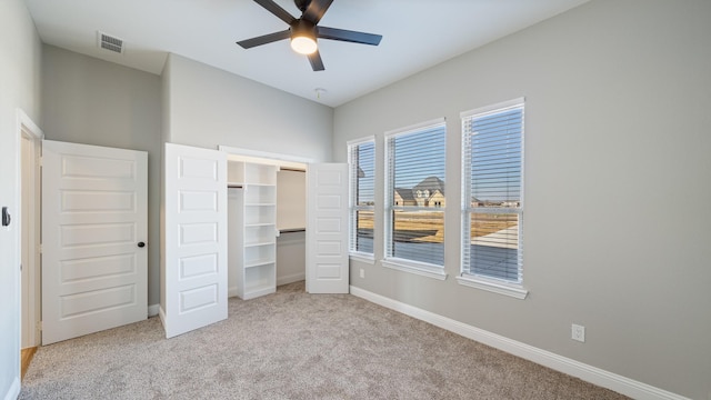 unfurnished bedroom with light colored carpet, ceiling fan, and a closet