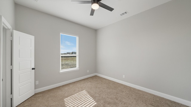 empty room featuring ceiling fan and light carpet