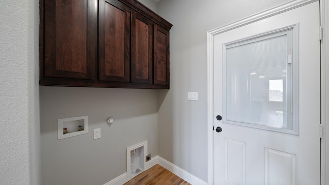 laundry room featuring gas dryer hookup, hardwood / wood-style floors, hookup for a washing machine, cabinets, and hookup for an electric dryer