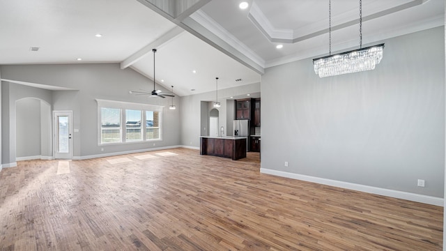 unfurnished living room featuring crown molding, ceiling fan, hardwood / wood-style floors, high vaulted ceiling, and beamed ceiling