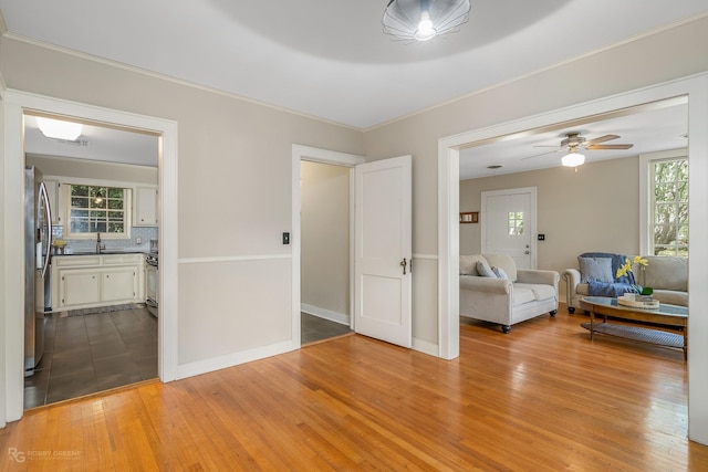 living room featuring ceiling fan, sink, and light hardwood / wood-style flooring