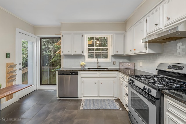 kitchen featuring stainless steel appliances, white cabinetry, dark stone countertops, and sink